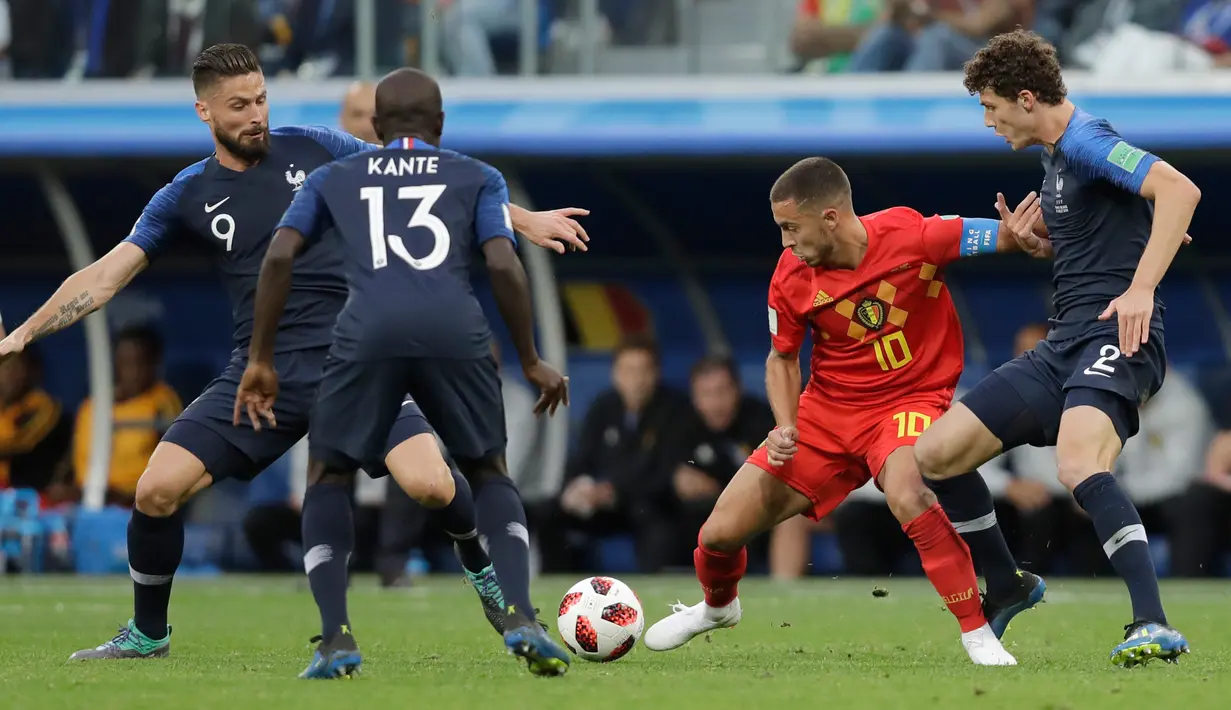 Pemain timnas Belgia, Eden Hazard berebut bola dengan pemain Prancis, Benjamin Pavard dan Prancis Olivier Giroud pada babak semifinal  di Stadion St. Petersburg, Selasa (10/7). Timnas Prancis berhasil menang 1-0 atas timnas Belgia. (AP/Natacha Pisarenko)