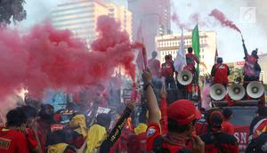 Sejumlah buruh menyalakan bom asap saat menutup aksi Hari Buruh Internasional di Jalan Medan Merdeka Barat, Jakarta, Rabu (5/1/2019). Aksi May Day 2019 di Jakarta ditutup oleh buruh dengan menyalakan kembang api sebagai simbol berjalannya demo dengan damai. (Liputan6.com/Helmi Fithriansyah)