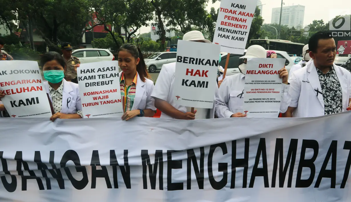Sejumlah massa yang menamakan diri dari Pergerakan Dokter Muda Indonesia membentangkan spanduk saat melakukan aksi di depan Istana Negara, Jakarta, Kamis (19/7). (Liputan6.com/Johan Tallo)