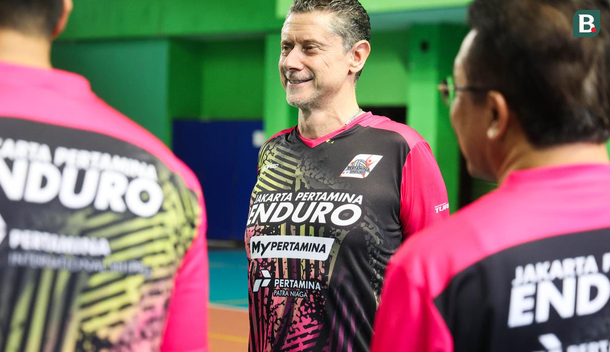 Pelatih Jakarta Pertamina Enduro, Bulent Karslıoglu, tampak santai dalam sesi latihan yang bertempat di GOR Bulungan, Jakarta Selatan pada Selasa (31/12/2024). (Bola.com/Abdul Aziz)