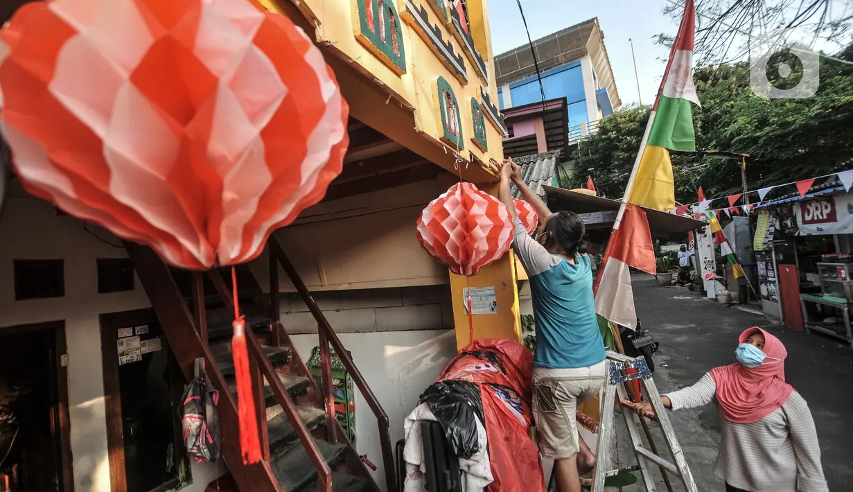 Warga menyelesaikan pemasangan ornamen bernuansa Kemerdekaan RI di "Kampung Merdeka" RW 04 Kelurahan Kebon Melati, Tanah Abang, Jakarta, Rabu (11/8/2021). Warga setempat menyulap permukiman padat yang berada di antara gedung bertingkat itu menjadi "Kampung Merdeka". (merdeka.com/Iqbal S Nugroho)