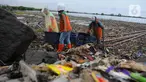Petugas Suku Dinas Lingkungan Hidup Kepulauan Seribu membersihkan sampah di pesisir Marunda Kepu, Cilincing, Jakarta, Jumat (16/6/2023).(merdeka.com/imam buhori)