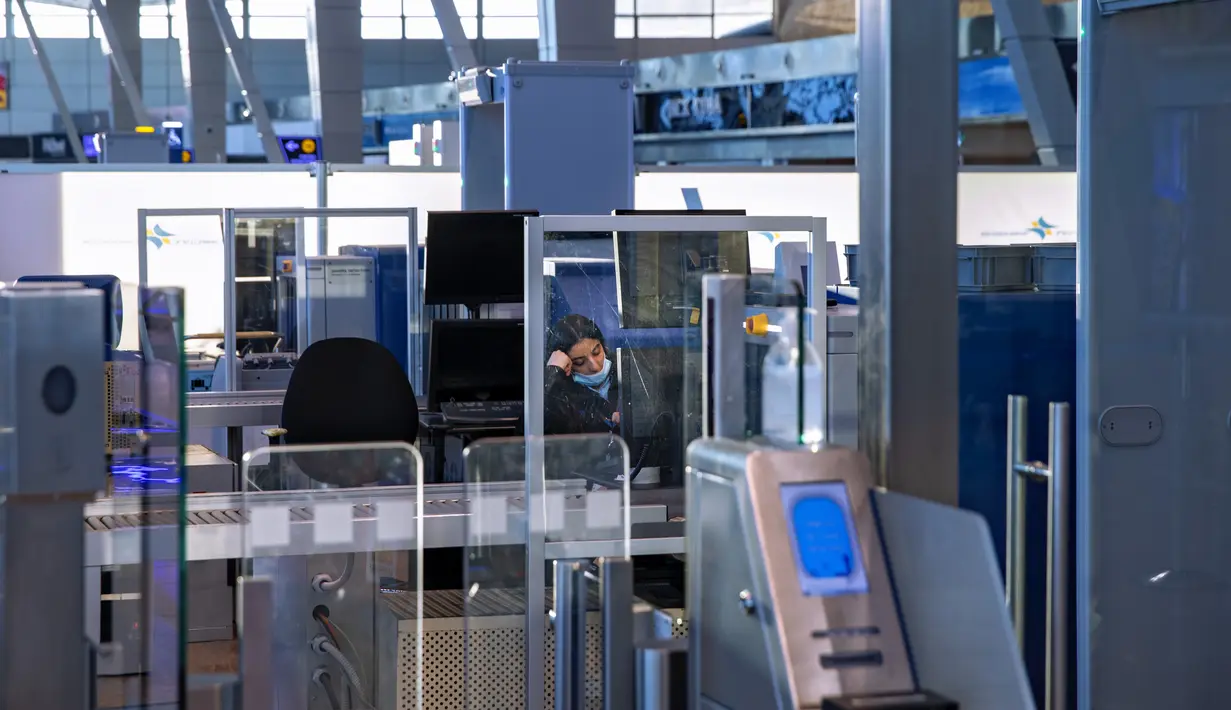 Seorang agen administrasi keamanan transportasi duduk di pos pemeriksaan di Bandara Ben Gurion di Lod, Selasa (26/1/2021). Bandara internasional utama Israel itu kosong setelah pemerintah menyetujui penutupan selama seminggu untuk mencegah penyebaran varian baru virus corona. (AP Photo/Oded Balilty)