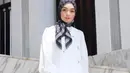 Tampilan clean dan elegan salah satunya bisa ditiru dari gaya Citra Kirana berikut ini. Ia memadukan blazer dan rok a-line serba putih dengan hijab monogram hitam.