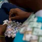 Wilmer Rojas (25) saat membuat tas dari lembaran mata uang Bolivar di Caracas, Venezuela, 30 Januari 2018. Inflasi yang tinggi membuat mata uang tersebut terus kehilangan nilainya. (AFP Photo/Federico Parra)