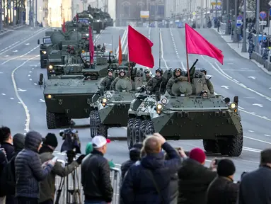 Penonton menyaksikan kendaraan lapis baja Rusia yang dihiasi bendera merah di sepanjang jalan Tverskaya menuju Lapangan Merah untuk menghadiri latihan parade militer Hari Kemenangan di Moskow, Rusia, Rabu (4/5/2022). Pawai akan berlangsung pada Mei 9 untuk merayakan 77 tahun kemenangan dalam Perang Dunia II. (Foto AP/Alexander Zemlanichenko)