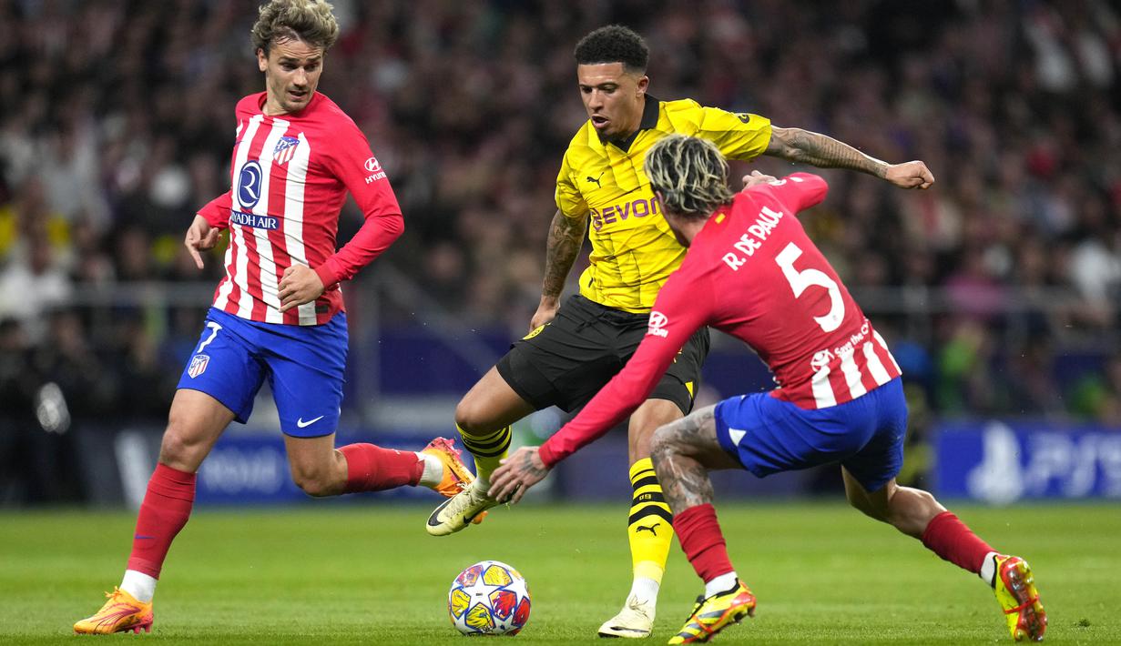 Pemain Atletico Madrid, Rodrigo De Paul, berusaha mengadang pemain Borussia Dortmund, Jadon Sancho, pada leg pertama perempat final Liga Champions di Stadion Metropolitano, Kamis (11/4/2024). (AP Photo/Manu Fernandez)