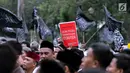 Peserta aksi membawa poster saat berunjuk rasa di Pintu Barat Monas, Jakarta, Selasa (18/7). Terlihat massa memadati pintu Barat Monas dengan membawa atribut aksi spanduk dan bendera. (Liputan6.com/Faizal Fanani)