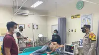 Korban Alex, terbaring dengan luka bacokan di bagian pinggangnya, saat dirawat di rumah sakit di Palembang Sumsel (Liputan6.com / Nefri Inge)