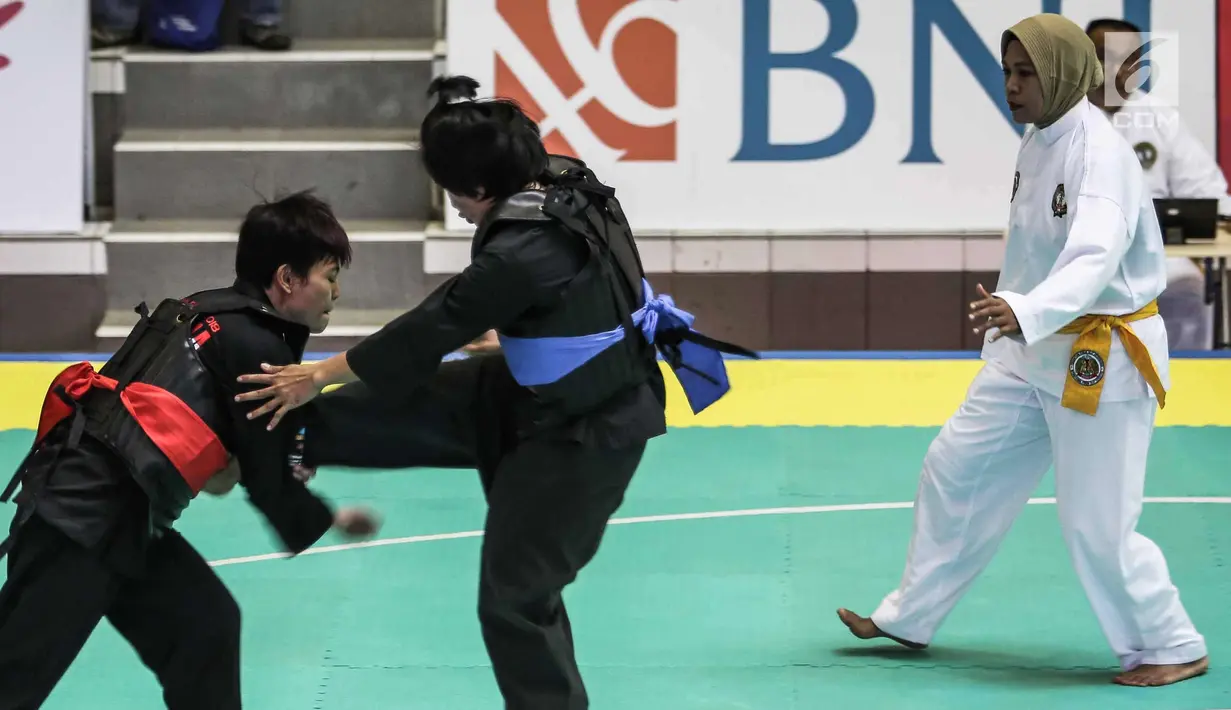 Pesilat Nirmalasari Oktaviani berusaha menahan tendangan pesilat Laos Olathai Sounthavong di semifinal 50-55 kg putri cabang Pencak Silat 18th Asian Games Invitation Tournament, Jakarta, Senin (12/2). Indonesia menang 5-0. (Liputan6.com/Faizal Fanani)