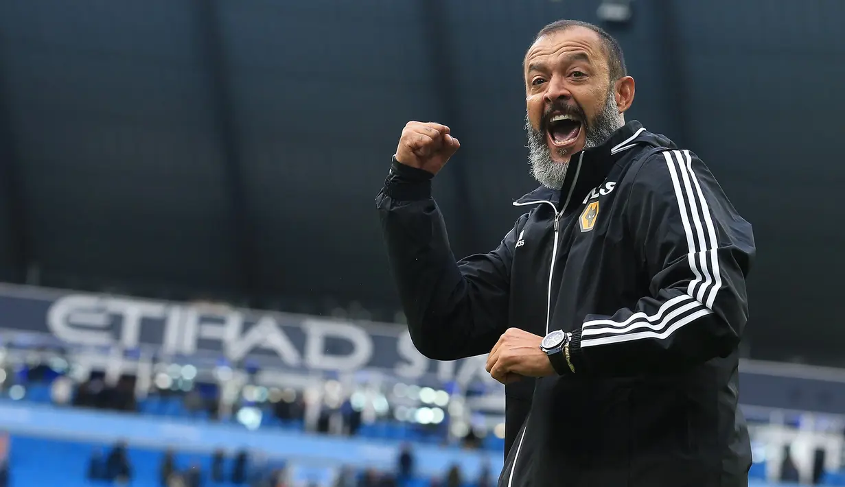 Pelatih Wolverhampton Wanderers, Nuno Espirito Santo menyapa para suporter saat berselebrasi usai pertandingan melawan Manchester City pada pertandingan lanjutan Liga Inggris di Stadion Etihad (6/10/2019). Wolverhampton menang 2-0 atas Manchester City. (AFP Photo/Lindsey Parnaby)