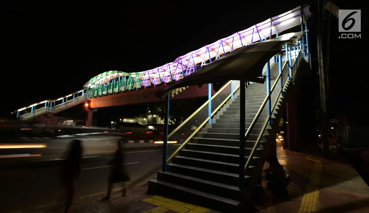Lampu yang bisa berganti-ganti warna menghiasi jembatan penyeberangan orang (JPO) di kawasan Jakarta Timur, Kamis (27/12). Jembatan ini dihiasi warna warni lampu dengan fasilitas lift untuk para disabilitas menyeberang jalan. (Merdeka.com/Imam Buhori)