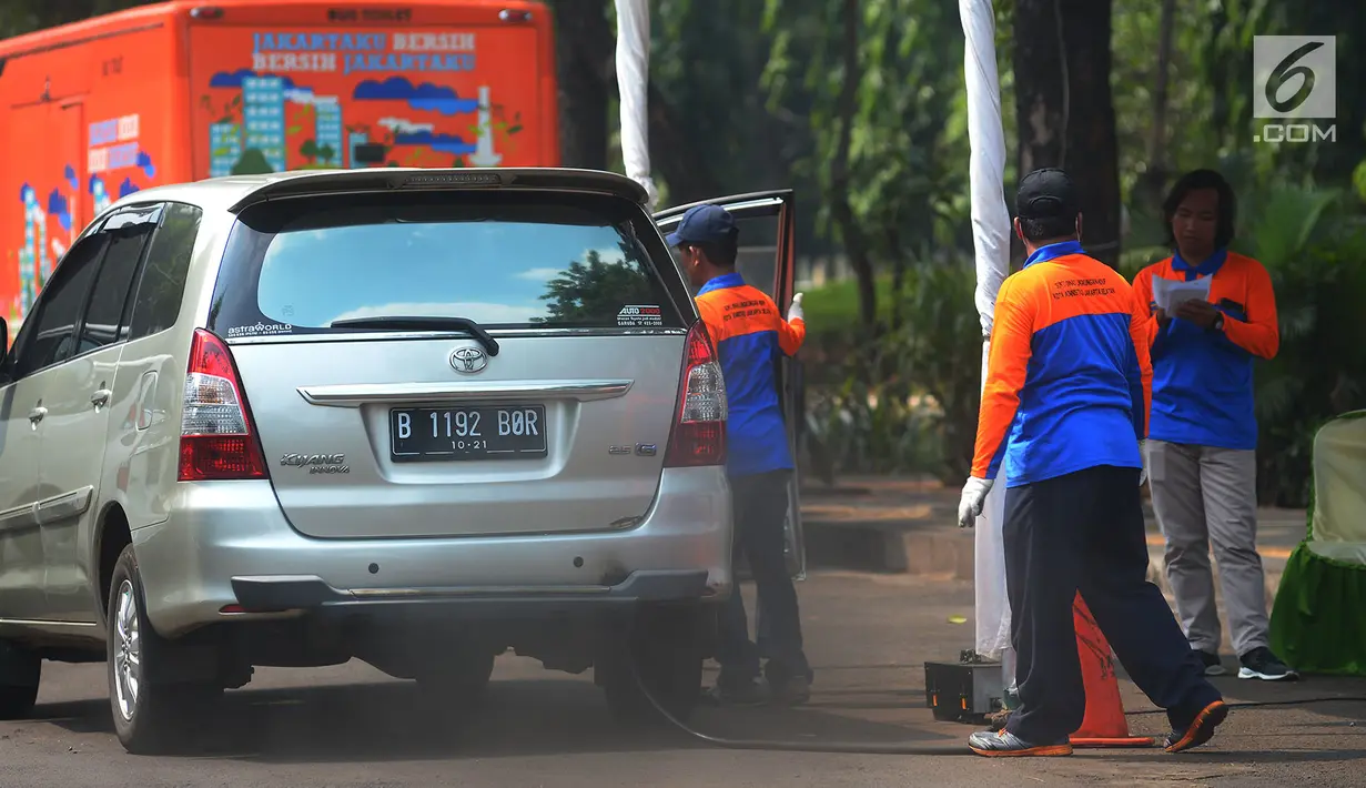 Petugas saat melakukan uji emisi mobil di Kalibata, Jakarta, Rabu (24/7). Uji emisi kendaraan di lakukan untuk kadar kualitas udara perkotaan, seiring meningkatnya volume kendaraan bermotor di kota-kota besar. (Merdeka.com/Imam Buhori)