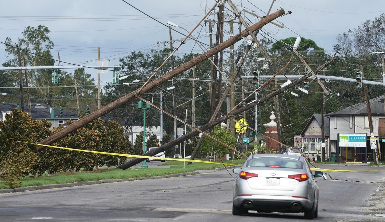 Lalu lintas dialihkan di sekitar jaringan listrik yang tumbang di Metairie, Louisiana, Senin (30/8/2021). Badai Ida ini sebagai salah satu badai paling kuat yang pernah melanda Amerika Serikat. (AP Photo/Steve Helber)