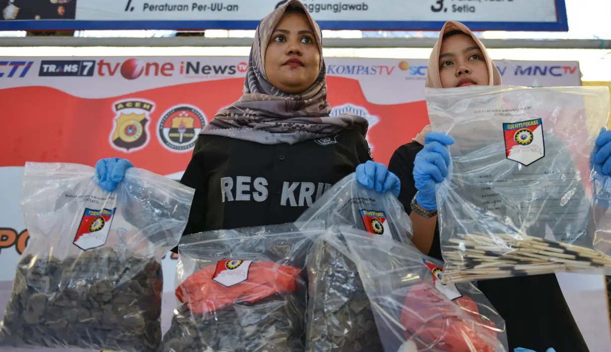 Petugas kepolisian memperlihatkan barang bukti sisik satwa trenggiling dan bulu landak saat konferensi pers di Mapolresta Banda Aceh, Aceh, Rabu (21/8/2019). Bagian tubuh satwa dilindungi ini diduga dipakai sebagai bahan dasar pembuatan narkotika dan kosmetik. (CHAIDEER MAHYUDDIN/AFP)