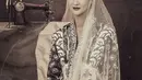 Atiqah Hasiholan bertatap nanar saat perankan Fatmawati. Ia mengenakan kebaya bermotif batik dan kerudung tipis [@yudajulianofficial]