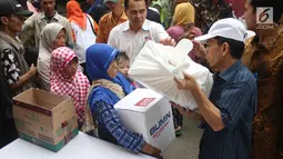 Warga menerima paket sembako Ramadan dari BUMN di Kecamatan Penjaringan, Jakarta, Selasa (13/6). Satu paket sembako yang dibagikan di Jalan Rawa Bebek ini senilai Rp 350 ribu, yang terdiri dari bahan kebutuhan pokok. (Liputan6.com/Angga Yuniar)