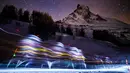Sejumlah peserta berjalan di malam hari saat mengikuti lomba Patroli Gletser dengan latar belakang gunung Matterhorn di resor ski Zermatt, Swiss (17/4). Lomba ini berlangsung dari 17 hingga 21 April. (Valentin Flauraud/Keystone via AP)