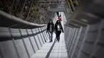 Orang-orang berjalan melewati Jembatan 516 Arouca di Arouca, Portugal (29/4/2021). Jembatan 516 Arouca merupakan jembatan gantung terpanjang di dunia yang membentang sejauh 516 meter di ketinggian 175 meter. (AFP/Carlos Costa)
