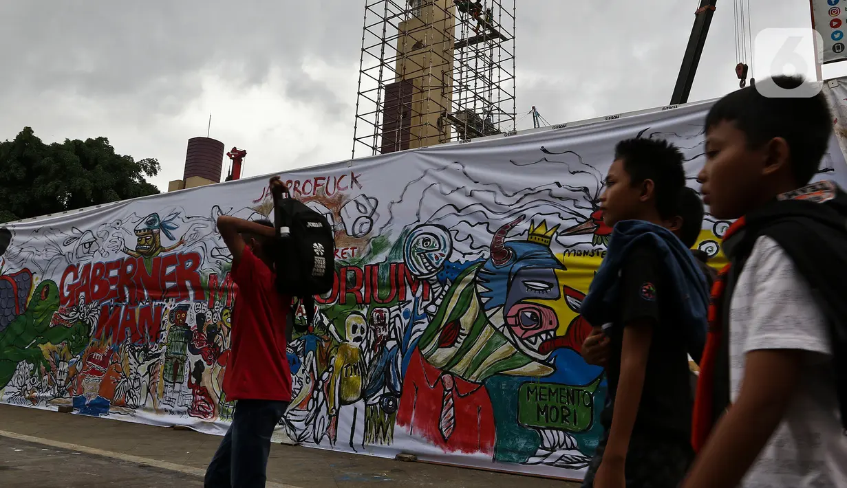Warga berjalan di samping proyek revitalisasi Taman Ismail Marzuki (TIM) yang dipenuhi lukisan bentuk protes, Jakarta, Sabtu (29/2/2020). Kebijakan Pemprov DKI Jakarta merevitalisasi TIM dinilai cacat prosedural karena tidak pernah dibicarakan dengan seniman sebelumnya. (Liputan6.com/Johan Tallo)