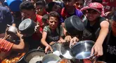 Warga Palestina berusaha mendapatkan makanan di dapur umum yang menyediakan makanan hangat di lingkungan Rimal, kota Gaza pada 18 Juni 2025. (Omar AL-QATTAA/AFP)