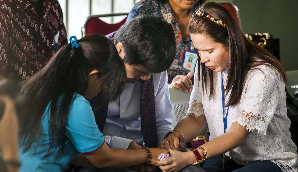 Manny Pacquiao (tengah) bersama istrinya Jinkee Pacquiao , dan Mary Jane (kiri), berdoa bersama di ruang kunjung Lapas Wirogunan. Yogyakarta, Jumat, (10/7/2015). Pacquiao didampingi Dubes Filipina untuk Indonesia Maria Lumen B. (REUTERS/Ignatius eswe)