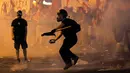 Salah satu pengunjuk rasa anti-bailout melemparkan bom molotov ke arah polisi di Athena, Yunani, Rabu (15/7/2015). Pengunjuk rasa menilai kesepakatan bailout bertentangan dengan hak semua orang, terutama kaum pekerja. (REUTERS/Yannis Behrakis)