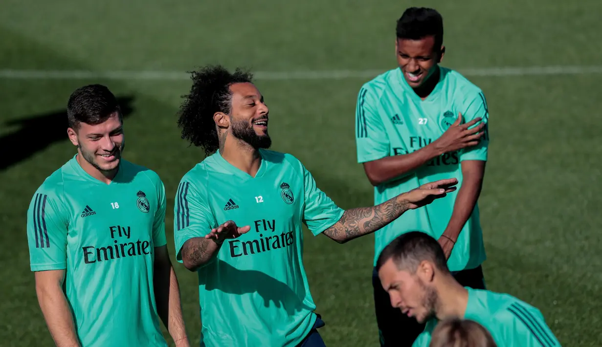 Bek Real Madrid Marcelo (dua kiri) bercanda dengan rekan-rekannya saat berlatih di kompleks latihan Valdebebas, Madrid, Spanyol, Senin (30/9/2019). Real Madrid bersiap jelang menjamu Club Brugge dalam laga Liga Champions. (AP Photo/Bernat Armangue)