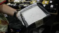 Petugas memperlihatkan barang bukti sabu saat rilis sindikat peredaran narkotika di Gedung BNN, Jakarta, Jumat (28/10). Sebanyak 50.000 butir H5, 39 kg sabu dan 98.960 butir ekstasi berhasil diamankan dari tiga tersangka. (Liputan6.com/Yoppy Renato)
