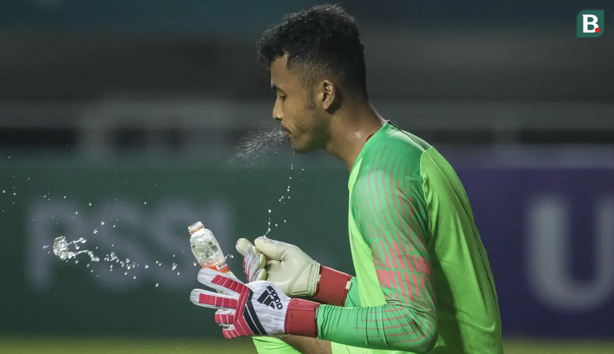Kiper Timnas Indonesia, Aqil Savik, melepas dahaga saat melawan Thailand pada laga PSSI 88th U-19 di Stadion Pakansari, Jawa Barat, Minggu (23/9/2018). Kedua negara bermain imbang 2-2. (Bola.com/Vitalis Yogi Trisna)
