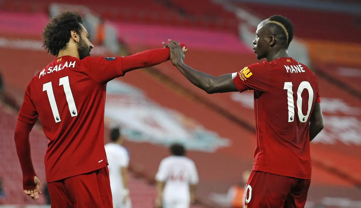 Penyerang Liverpool, Sadio Mane, melakukan selebrasi bersama Mohamed Salah usai membobol gawang Crystal Palace pada laga Premier League di Stadion Anfield, Rabu (24/6/2020). Liverpool menang dengan skor 4-0. (AP/Phil Noble)