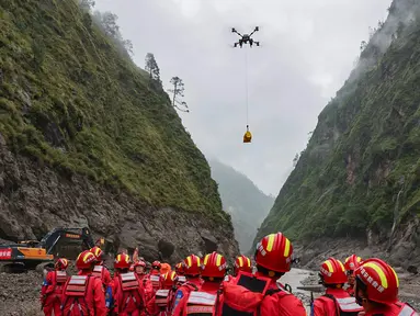 Sebuah drone membawa muatan melintasi udara saat operasi pencarian dan penyelamatan berlangsung di wilayah yang dilanda tanah longsor di Kabupaten Gyirong, Daerah Otonom Tibet, Tiongkok barat daya, Sabtu, 29 Agustus 2026. (Jiang Fan/Xinhua via AP)