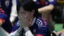 Salah satu suporter di Tokyo menutup wajah menahan kesedihan usai menyaksikan kegagalan Timnas Jepang menembus zona 16 Piala Dunia 2014, (25/6/2014). (REUTERS/Issei Kato) 