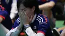 Salah satu suporter di Tokyo menutup wajah menahan kesedihan usai menyaksikan kegagalan Timnas Jepang menembus zona 16 Piala Dunia 2014, (25/6/2014). (REUTERS/Issei Kato) 