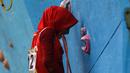 Atlet Panjat Tebing DKI Jakarta, Syarifah mengigit tali karmantel saat memanjat pada kategori Lead Cabang Panjat Tebing PON XIX Jabar 2016 di Cikole, Bandung. (Bola.com/NIcklas Hanoatubun)