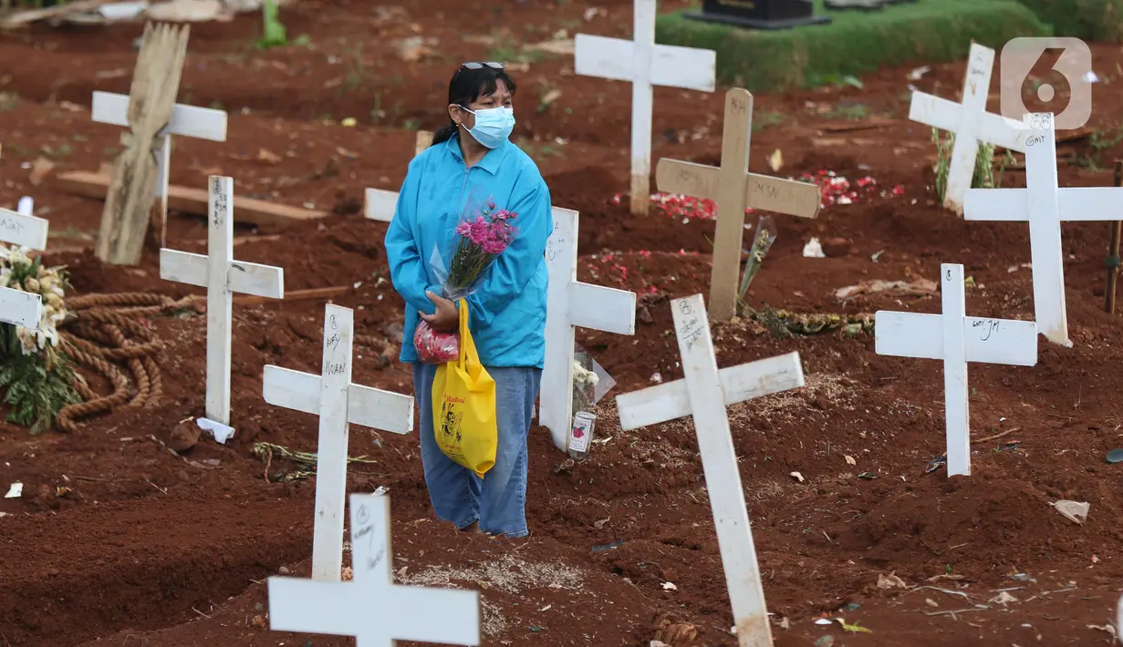 Warga berada di tengah-tengah area pemakaman jenazah dengan protokol COVID-19 di TPU Pondok Ranggon, Jakarta, Kamis (12/10/2020). Gubernur DKI Jakarta Anies Baswedan menganggarkan Rp254 miliar guna menambah lahan pemakaman jenazah dengan protokol Covid-19. (Liputan6.com/Helmi Fithriansyah)
