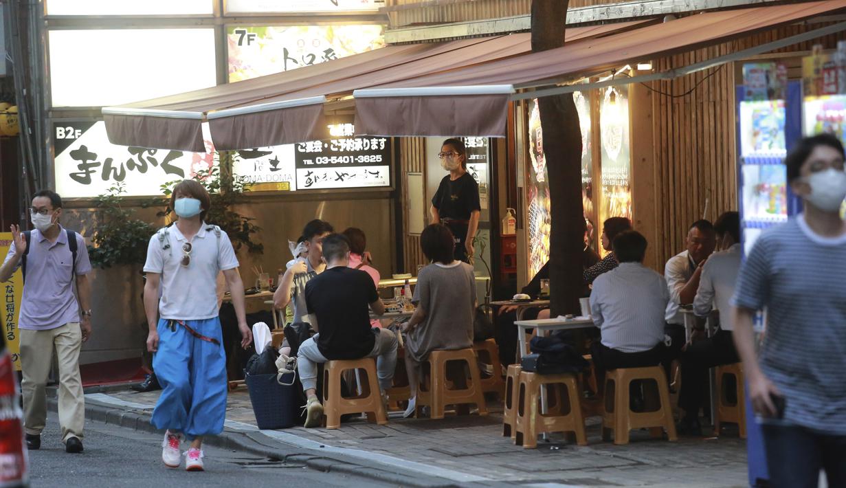 Orang-orang minum di bar selama keadaan darurat COVID-19 di Tokyo, Jepang pada Senin (12/7/2021). Status darurat keempat di Tokyo ini, yang berlaku hingga 22 Agustus, akan mencakup durasi gelaran Olimpiade Tokyo. (AP Photo/Koji Sasahara)