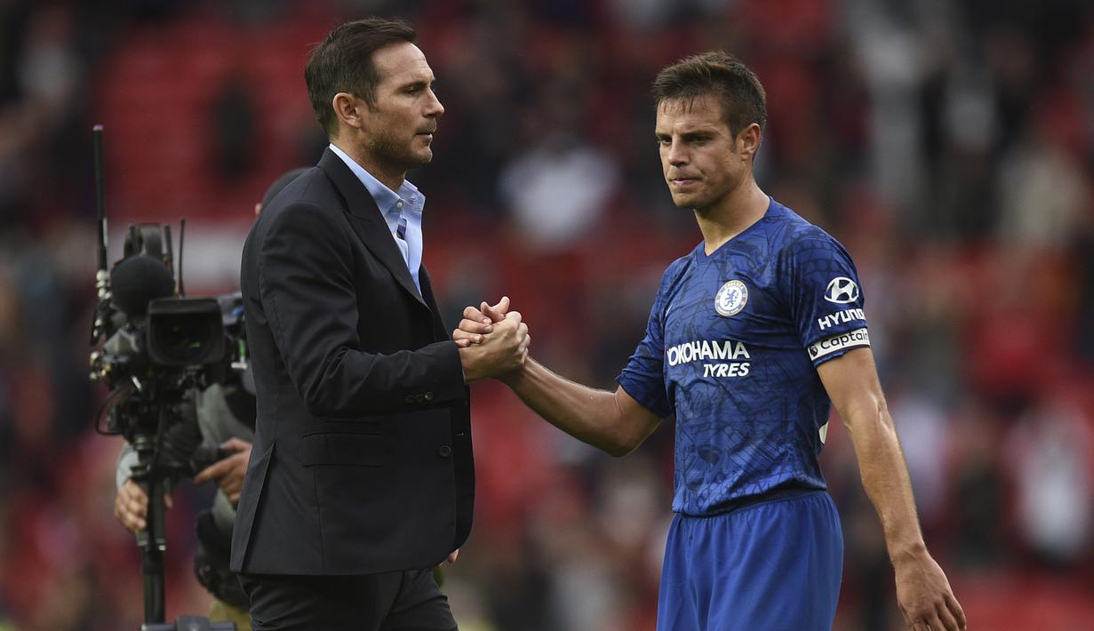 Pelatih Chelsea, Frank Lampard (kiri) berjabat tangan dengan bek Cesar Azpilicueta  usai pertandingan melawan MU pada pertandingan perdana Liga Inggris di Old Trafford  (11/8/2019). MU menang telak 4-0 sekaligus menjadi mimpi buruk bagi debut Frank Lampard bersama Chelsea. (AFP Photo/Oli Scarff)