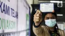 Warga menujukkan Kartu Vaksinasi COVID-19 saat mengikuti vaksinasi gratis di Stasiun MRT, Jakarta, Jumat (23/7/2021). Penyuntikan vaksin COVID-19 dosis pertama tersebut menargetkan 1.800 peserta. (Liputan6.com/Johan Tallo)