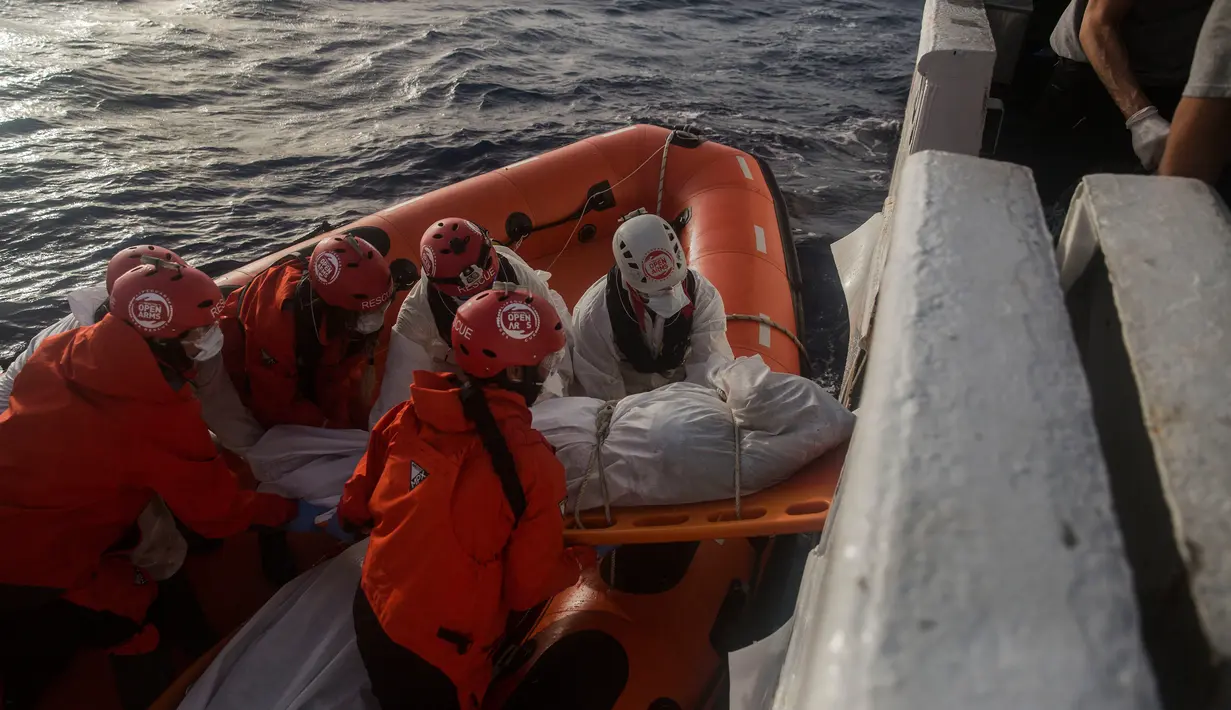 Petugas LSM Spanyol mengevakuasi mayat imigran Afrika sub-Sahara di tengah Laut Mediterania, lepas pantai Libya, Selasa (25/7). Petugas menemukan 13 mayat, termasuk ibu hamil dan anak-anak, di atas perahu karet yang membawa 160 migran. (AP/Santi Palacios)