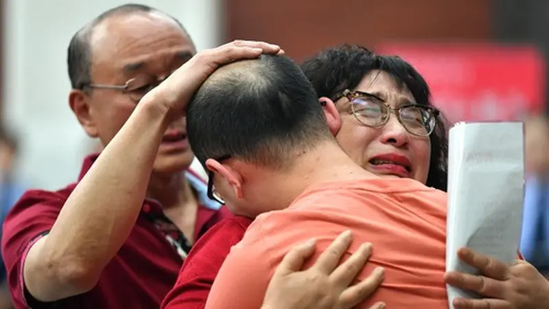 Mao Yin dan orang tuanya berpelukan di Biro Keamanan Masyarakat Kota Xi'an di Provinsi Shaanxi, China barat laut, pada 18 Mei 2020. (Xinhua/Zhang Bowen)