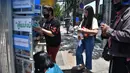 Seorang pria mengambil makanan yang disumbangkan oleh publik pada “Pantry of Sharing” di Bangkok, Thailand, Rabu (13/5/2020). Warga yang mampu menaruh kelebihan stok makanannya di lemari itu, sementara yang tidak mampu mengambil persediaan sesuai kebutuhan. (Lillian SUWANRUMPHA/AFP)