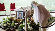 Seorang wanita berada dekat peti jenazah almarhum Ketua Umum Pengurus Besar Persatuan Atletik Seluruh Indonesia (PB PASI) Bob Hasan di Jakarta, Selasa (31/3/2020). Bob Hasan meninggal dunia di RSPAD Gatot Subroto Jakarta setelah sempat dirawat intensif selama tiga bulan. (Liputan6.com/Faizal Fanani)