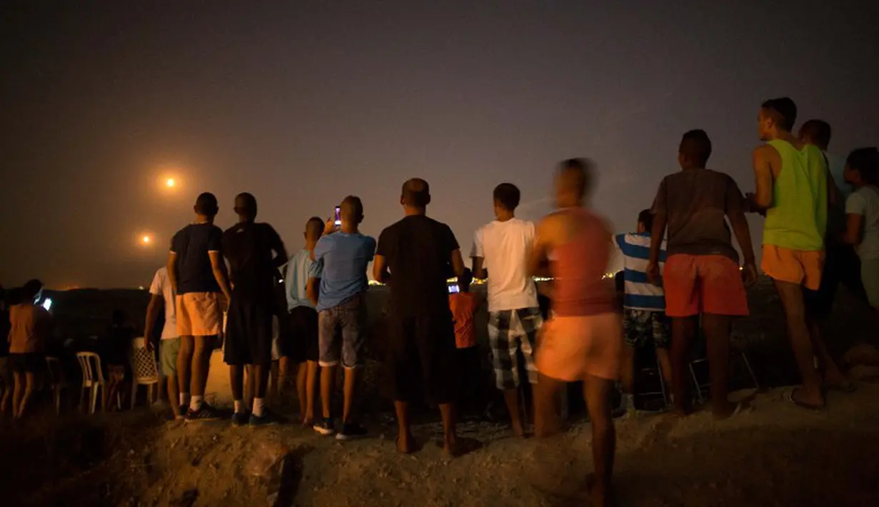 Di sebuah bukit di pinggiran  Kota Sderot, selatan Israel, sekitar 50 orang warga Israel asyik menonton serangan militer Israel ke jalur Gaza (AFP Photo/JACK GUEZ)