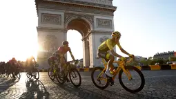Pebalap Kolombia Egan Bernal (kanan) melewati Arc de Triomphe saat mengikuti Tour de France 2019, Paris, Prancis, Minggu (28/7/2019 ). Egan Bernal memenangkan Tour de France 2019 setelah masuk Kota Paris dengan memimpin klasemen keseluruhan. (Julien de Rosa/ Thibault Camus)