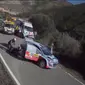 Pebalap dan navigator dari tim Hyundai World Rally Team ini secara kompak bekerja sama mendongkrak mobil dan melepas roda.