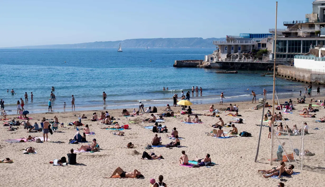 Orang-orang berjemur dan berenang di pantai Catalans (Plage des Catalans) di Marseille, Prancis Selatan, (17/4). Pantai ini memiliki dua lapangan voli pantai di mana beberapa kompetisi internasional diselenggarakan. (AFP Photo/Bertrand Langlois)