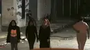 Sejumlah mengenakan masker saat berjalan ke rumah keluarga mereka selama penguncian yang diberlakukan selama pandemi virus corona, di kamp pengungsi Shati, di Kota Gaza, Selasa, (1/9/2020). (AP Photo/Adel Hana)