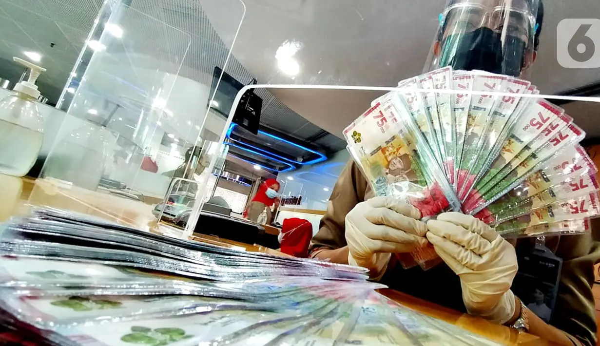 Teller menunjukkan uang tunai pecahan Rp75 ribu di Kantor Cabang Bank BTN Jakarta Harmoni, di Jakarta. Bank BTN mengalokasikan likuiditas dana senilai Rp13,4 triliun untuk memenuhi kebutuhan uang tunai nasabah perseroan pada Idul Fitri 1442 H selama 10 hari mulai 8-17 Mei. (Liputan6.com/HO/BTN)
