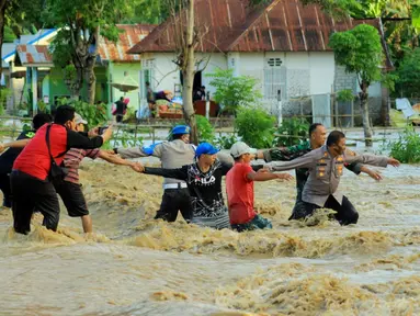 Petugas berusaha mengevakuasi warga saat banjir bandang  di Kabupaten Bone Bolango, Gorontalo (11/6/2020). Data sementara yang diterima dari BPBD Kabupaten Bone Bolango sekitar 1.078 kepala keluarga serta 5.407 jiwa terdampak banjir bandang. (Liputan.com/Arfandi Ibrahim)